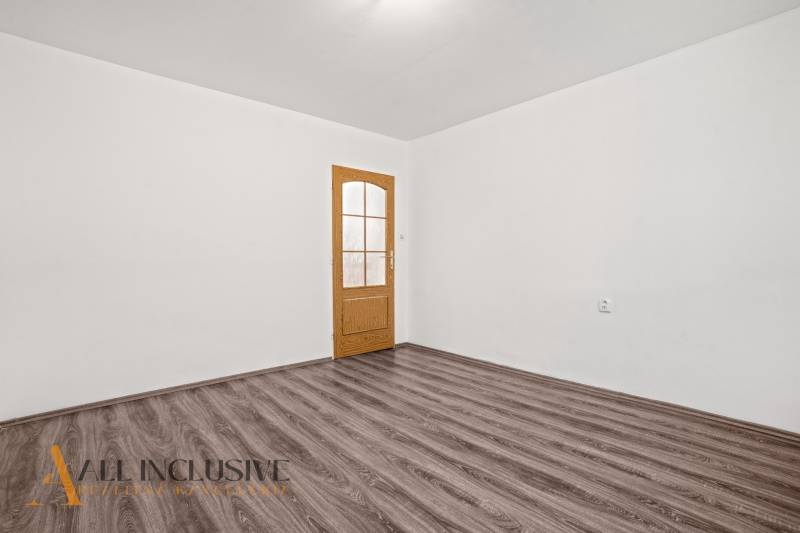 A white interior with doors and a wooden decor floor in a family house.