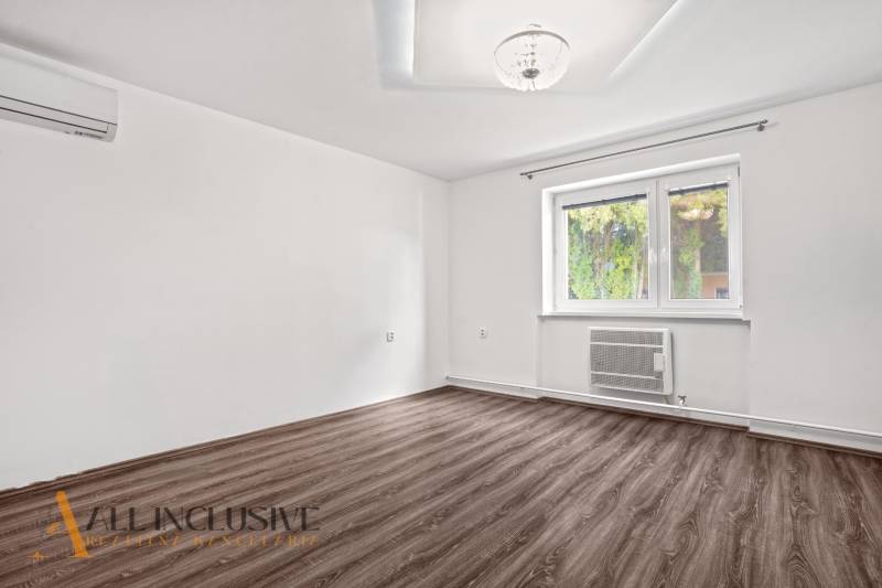 A room in a family house with a wooden decor floor and white walls.