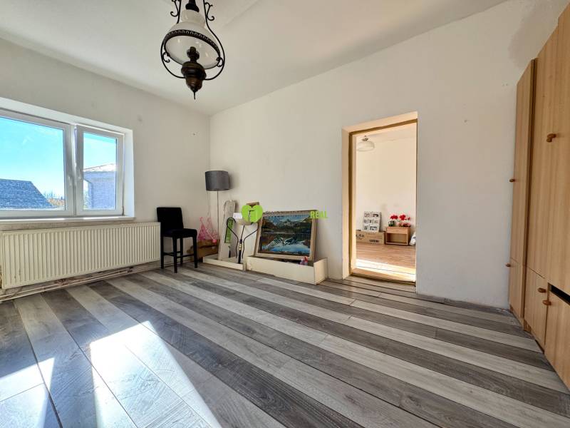 A room in a family house with a lamp, a painting, and a wooden decor floor.