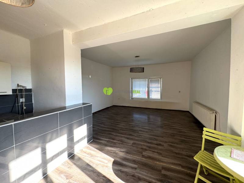 Interior of a family house with a spacious room, wooden decor flooring, and a dining area.