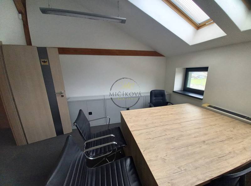 Interior of an office with a conference table and chairs, floor with wooden decor.