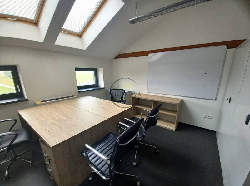 Office with chairs, a whiteboard, a table with a wooden decor, and skylights.