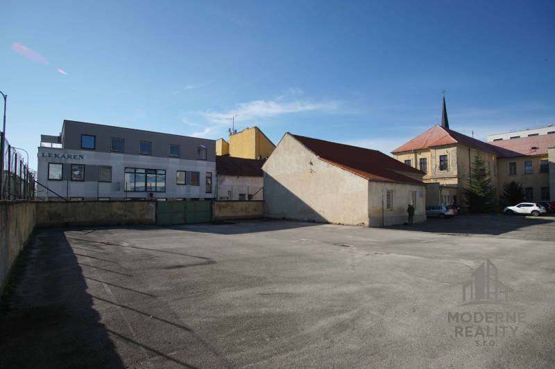 A parking lot surrounded by buildings in Nové Zámky, ideal for residential land.