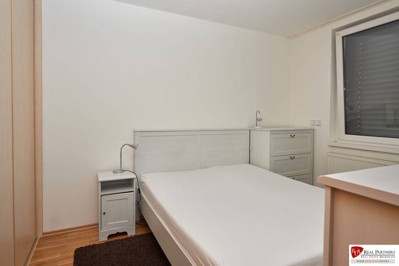 Bedroom in a 2-room apartment with a double bed, nightstand, and dresser.