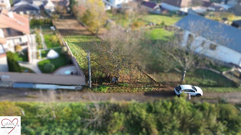 Plots - housing on M.H. Chvotekova Street in Dolna Krupa, with greenery and a parked car.