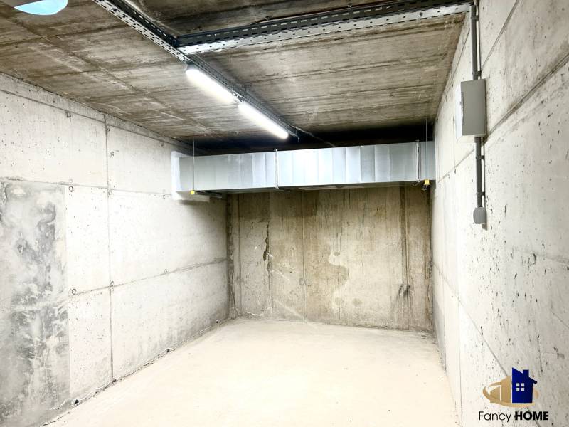 Concrete garage interior with lighting and ventilation.