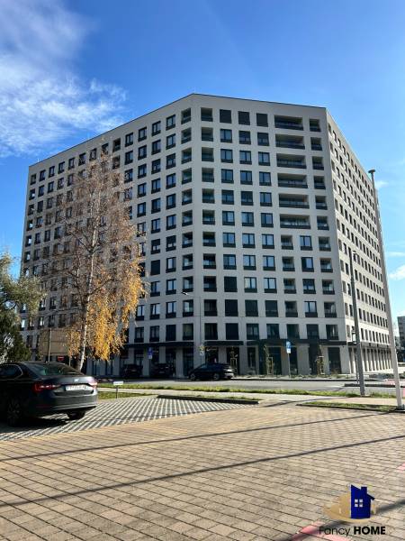 Apartment building on Karpatská Street in Poprad, surrounding parking lot and trees.