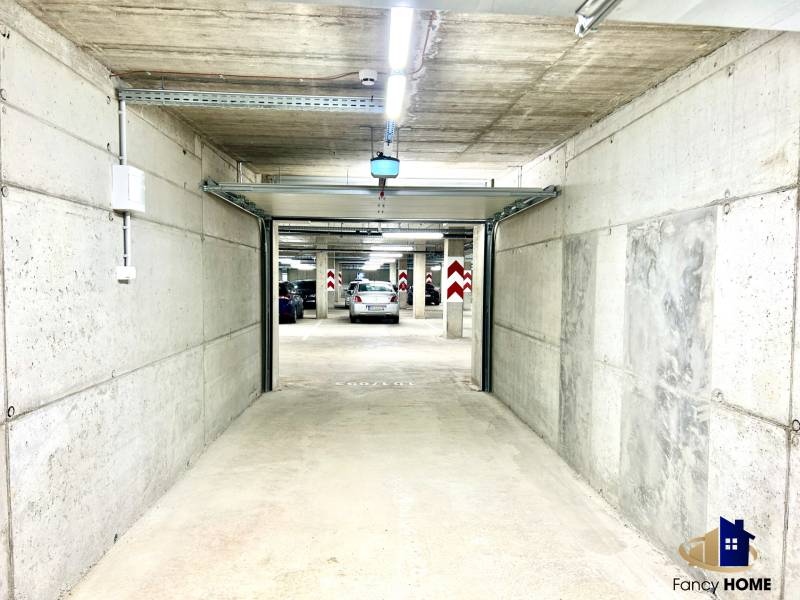 Concrete garages with open doors and parked cars.