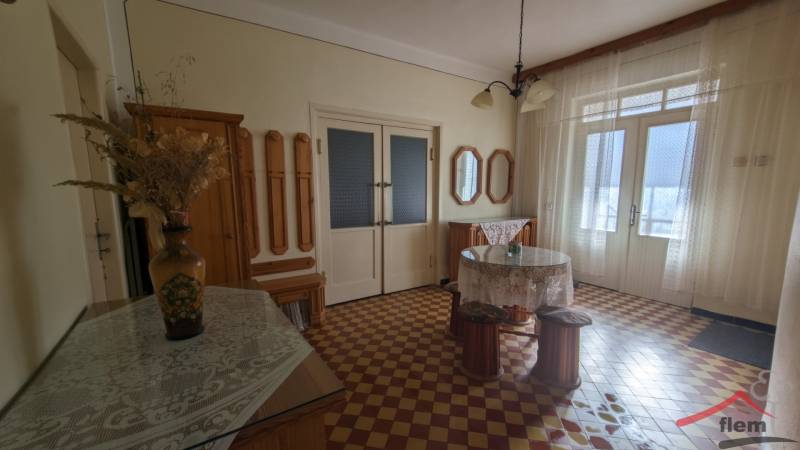 Interior of a family house with colorful tiles, a flower vase, and curtains.