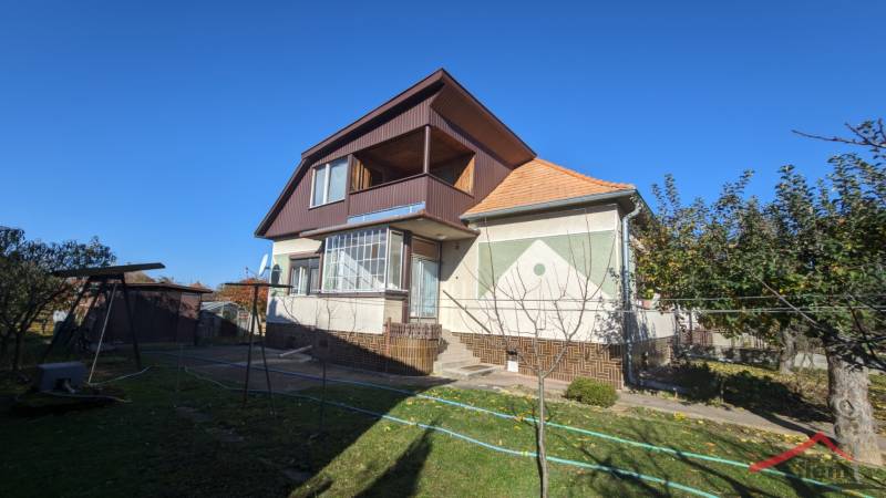 A family house in Vráble with an attic, a small terrace, and a garden with fruit trees.