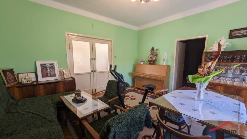 Living room in a family house with furniture, exercise equipment, and green walls.