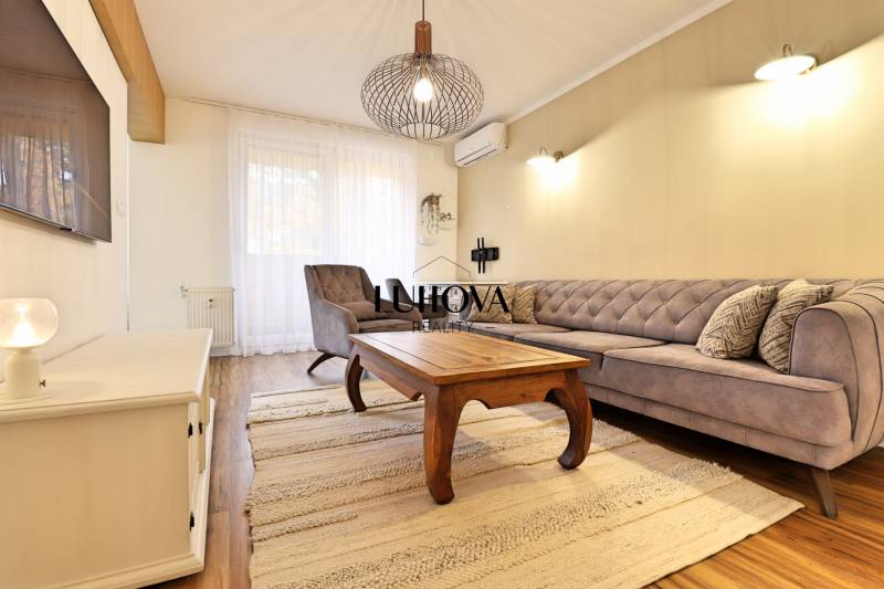 Living room in a 3-room apartment with a wood-patterned floor and stylish furniture.