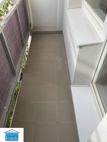 A narrow balcony with ceramic tiles in a studio apartment.