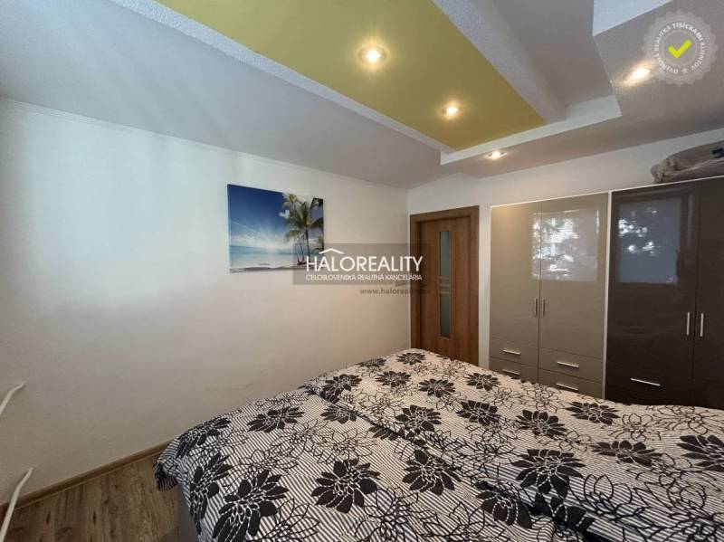 A bedroom in a 2-room apartment with a bed, a wardrobe, and a decorative ceiling.