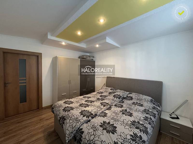 Bedroom with a bed and storage space in a 2-room apartment, floor with wood decor.