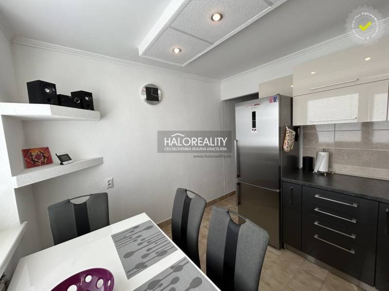 A kitchen in a 2-room apartment with a dining table and modern equipment.