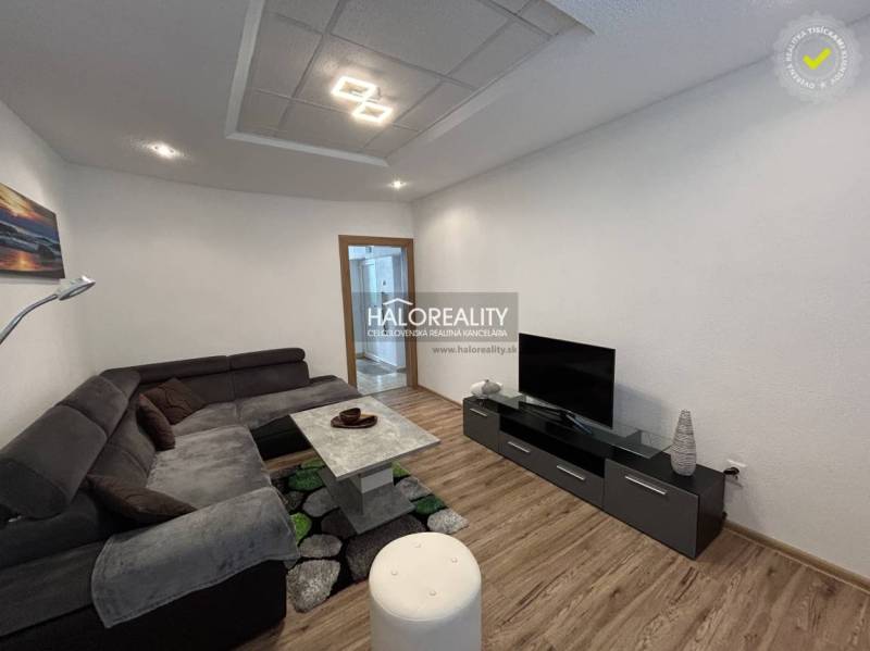 Living room with a sofa set, television, and wooden decor flooring in a two-room apartment.