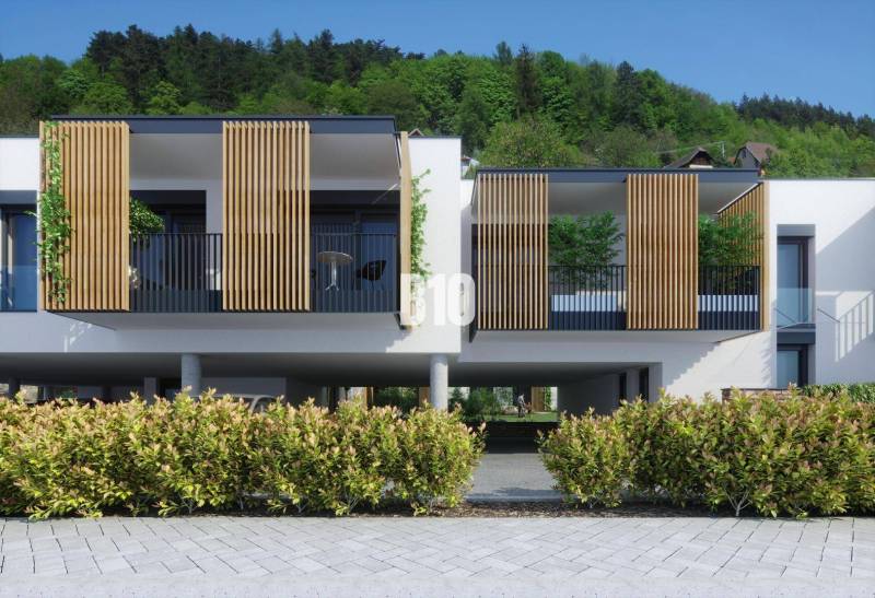 A modern building with wooden elements on Dolná Street in Žilina, surrounded by greenery.