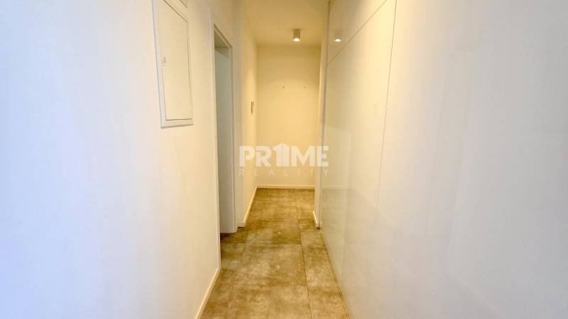 Hallway in a 2-room apartment with white walls and tiled floor.