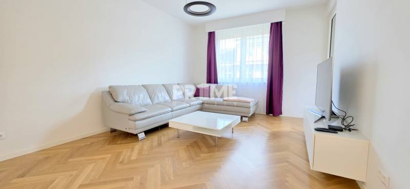 Living room with a corner sofa, purple curtains, and a wooden decor floor in a two-room apartment.
