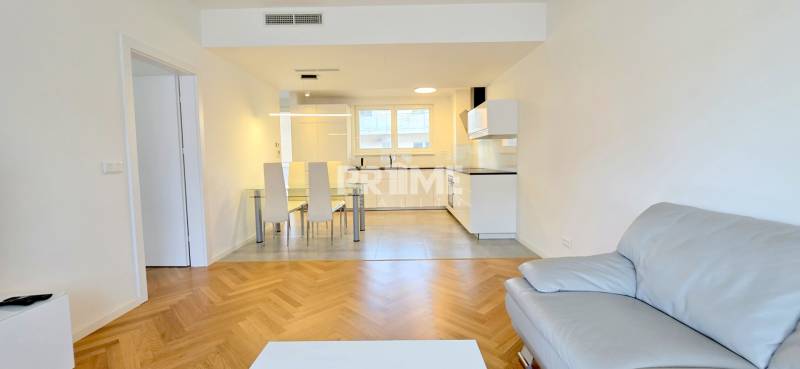 Kitchen with dining area and sofa, wooden decor flooring, 2-room apartment.