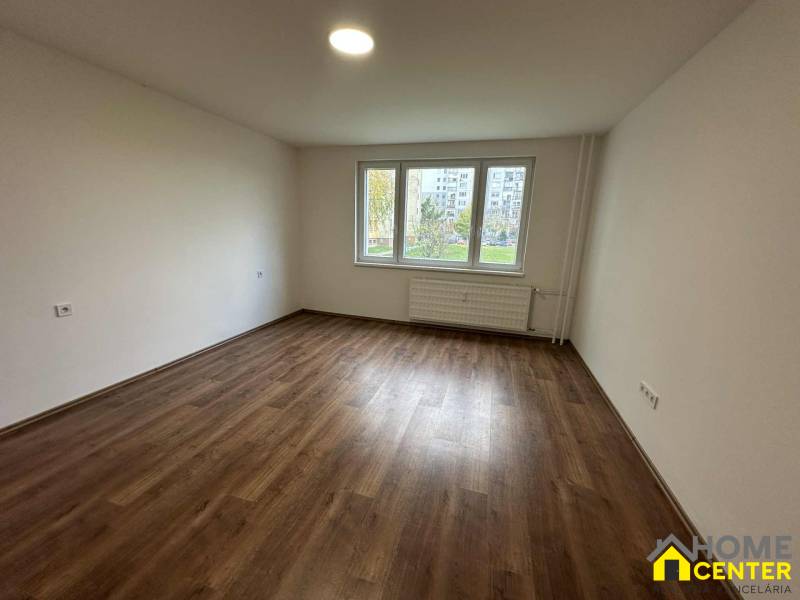 Two-room apartment with wood-patterned flooring, bright room with a wide window.