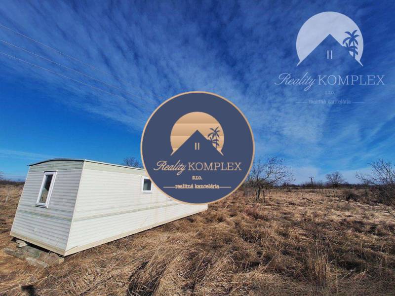 Mobile home on agricultural and forest land in Radvaň nad Dunajom under the blue sky.