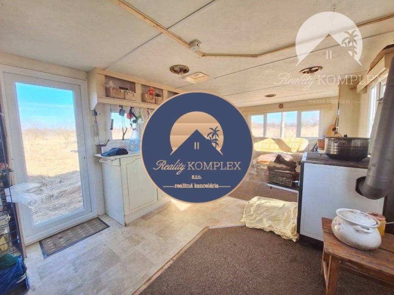 Interior with a kitchen, stove, and view of agricultural and forest land.