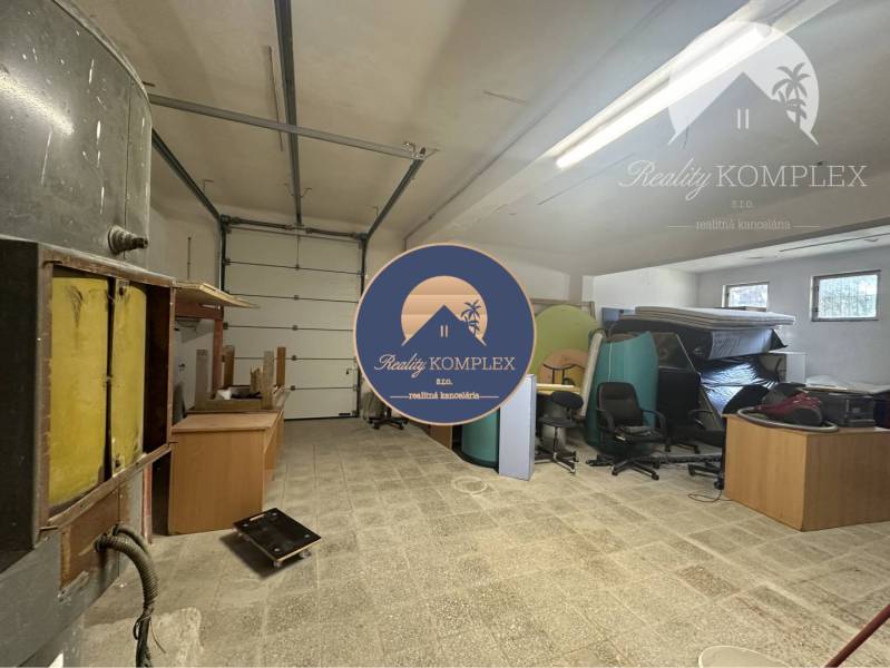 Commercial premises with storage space, office furniture, and industrial doors.