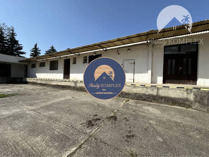 Commercial premises in Patince with a concrete area and a white facade.