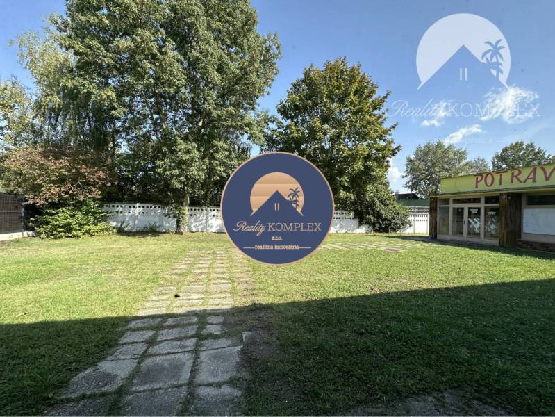 Commercial premises in Patince with a lawn and trees, groceries close to the left side.