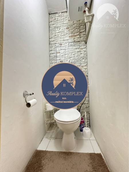 A bathroom in a studio apartment with tiles resembling stone.