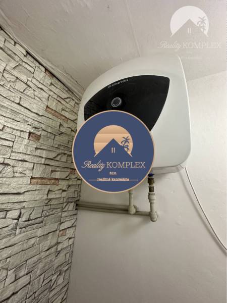 Heating unit in a studio apartment with stone cladding on the wall.