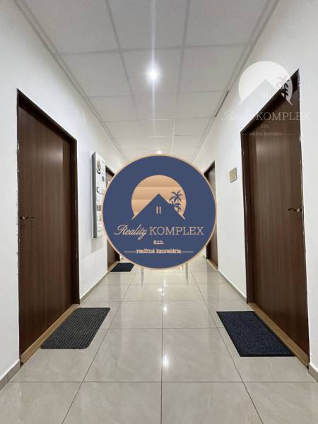 A corridor of offices with brown doors and shiny white floor.