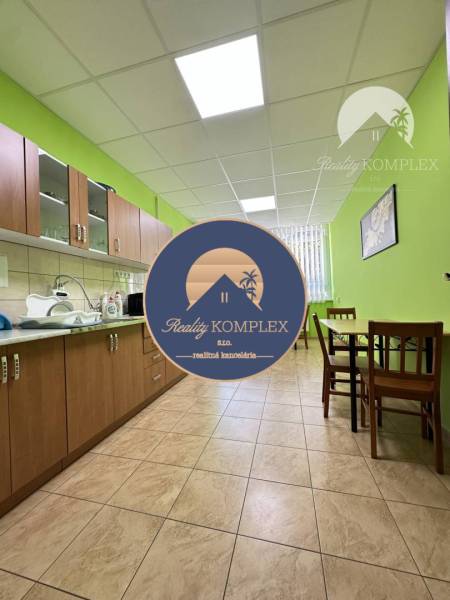 Offices with a kitchenette, wood-patterned flooring, light green walls, furniture, and dining area.