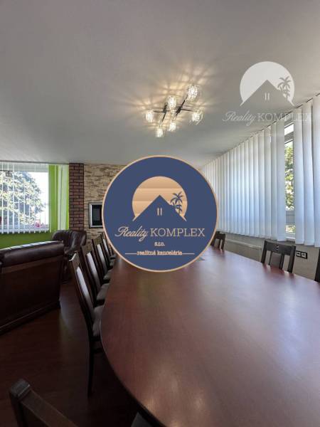 Conference table and chairs in an office with wood-patterned flooring.