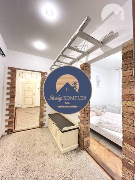 A carpet and brick walls in the hallway of a 3-room apartment.