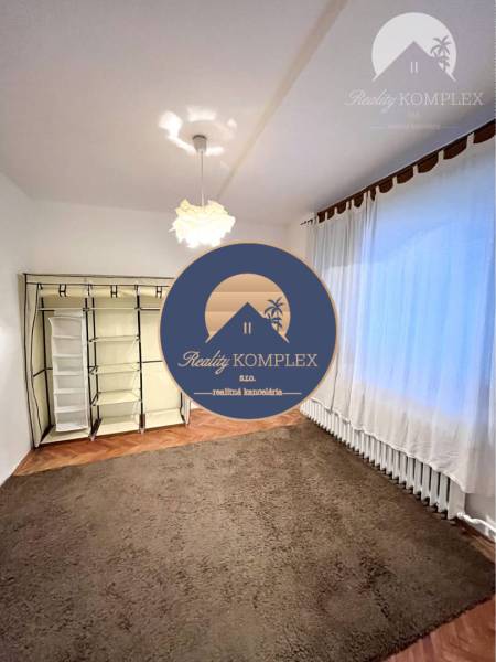 A room in a 3-room apartment with a carpet and a floor with a wooden decor.