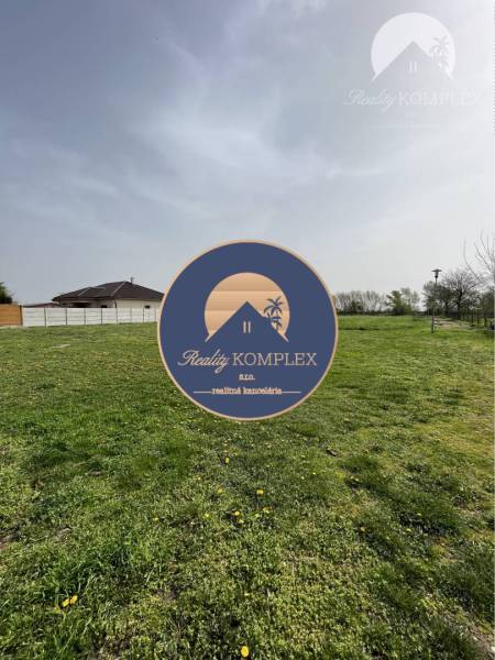 Green plots in Komárno suitable for living, with grassy surface and fencing.