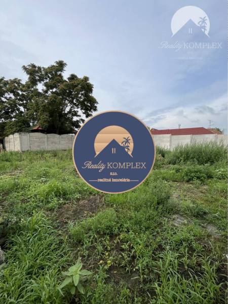 Plots - housing in Iža with grassy vegetation and fenced area.