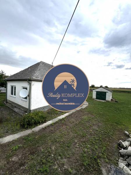 A family house in Komárno with an adjacent lawn and a satellite dish on the facade.