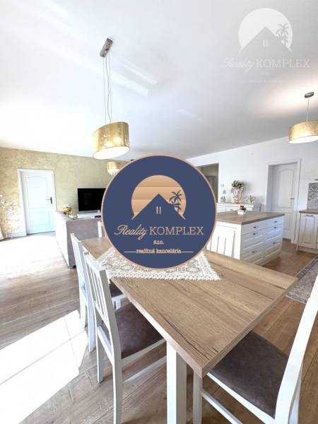 A dining room in a family house with a wood-patterned floor, light walls, pendant lights.