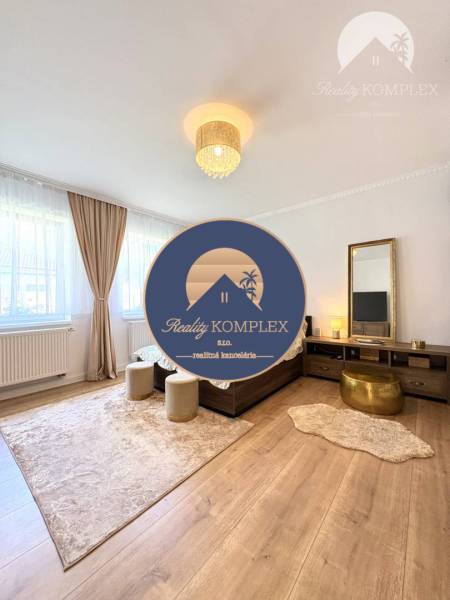 Bedroom in a family house with wood-patterned flooring, carpet, and chandelier lighting.