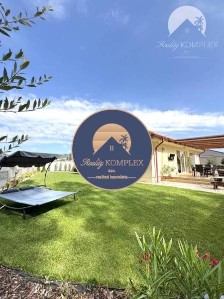 A garden at a family house in Dunajská Streda with a lounger and a terrace under the blue sky.