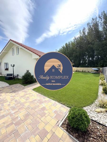 A family house in Dunajská Streda with a lawn and a paved walkway.