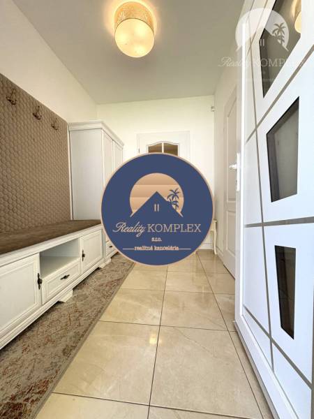 Entrance hall of a family house with white storage furniture and a coat rack.