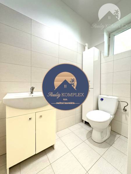 Bathroom in a family house with light tiles and sanitary ware, simple design.