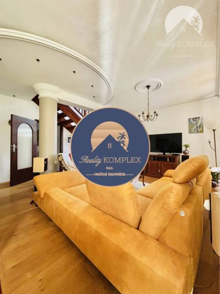 A family house with a wooden decor floor, staircase, sofa, and television.