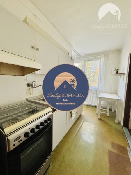 A kitchen in a 2-room apartment with a gas stove and a dining area.