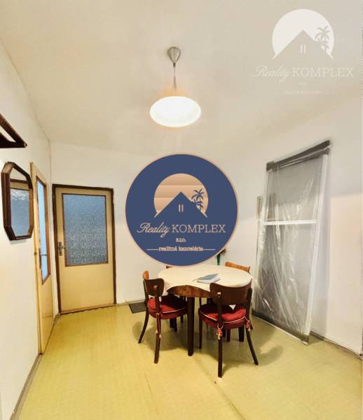 Dining room in a 2-room apartment with a simple wooden table and chairs.